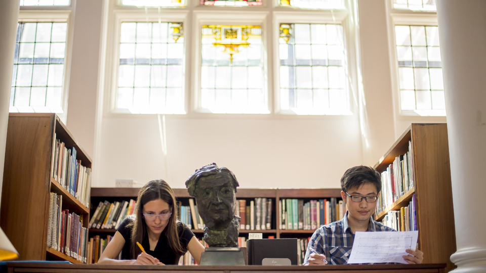 Students working beneath stained glass windows in the Donaldson Room in the RCM Library
